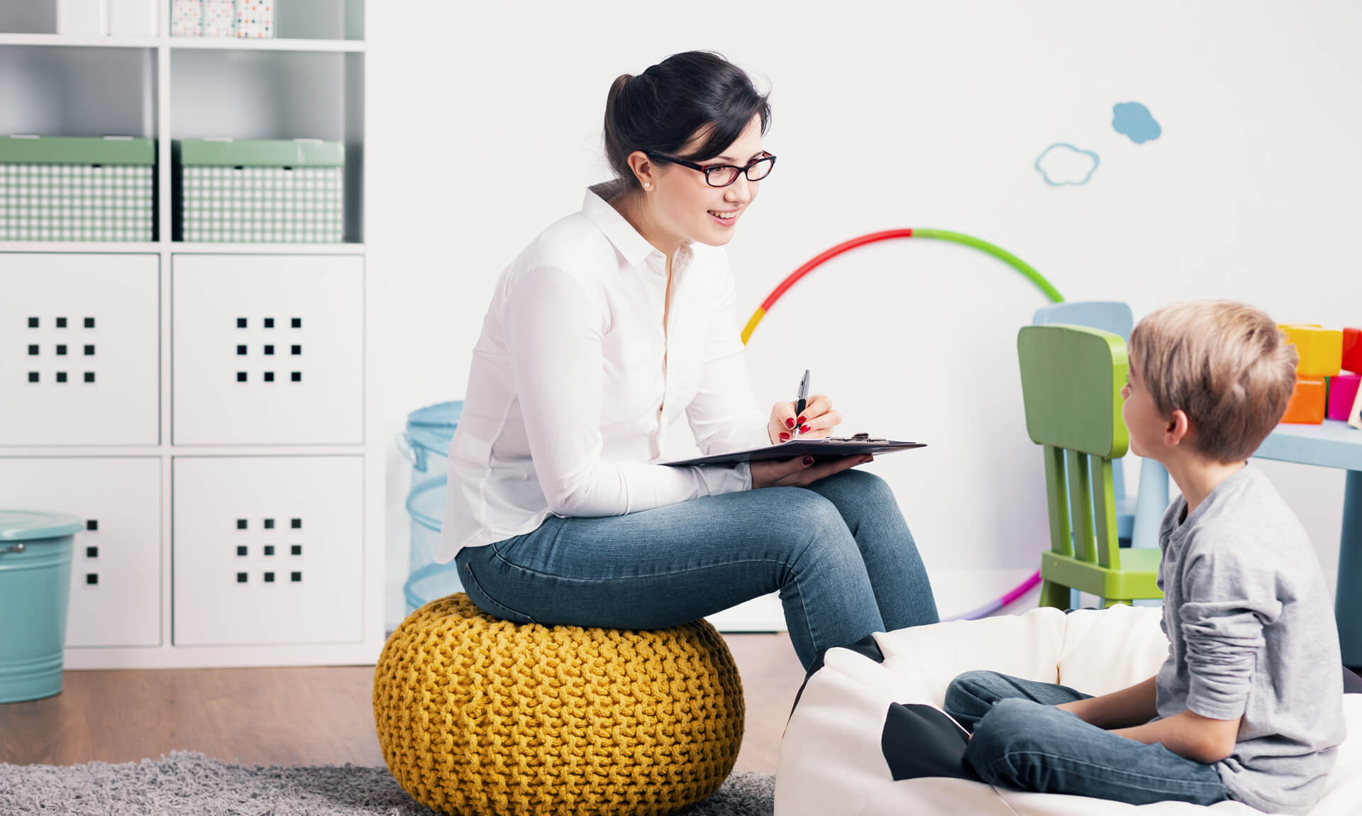 psychologist talking with kid during meeting in the classroom
