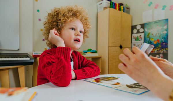 Teacher spreads out puzzle in front of the child