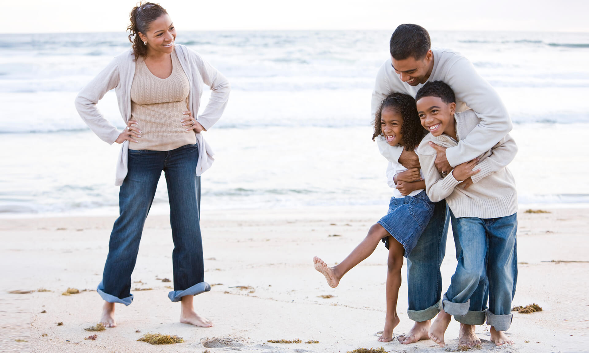 Happy family laughing on beach.
