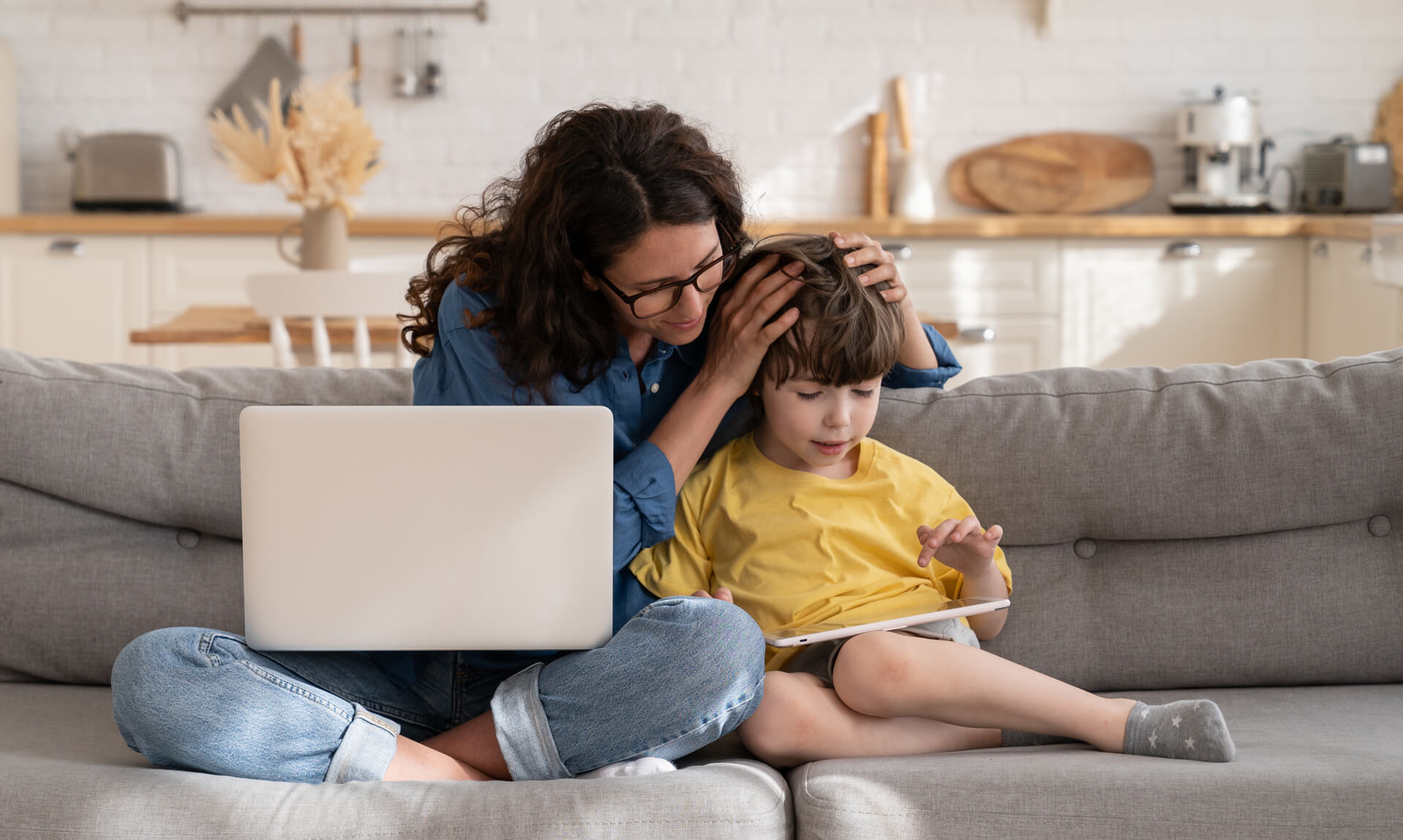 Mom helps preschool child with digital tablet.