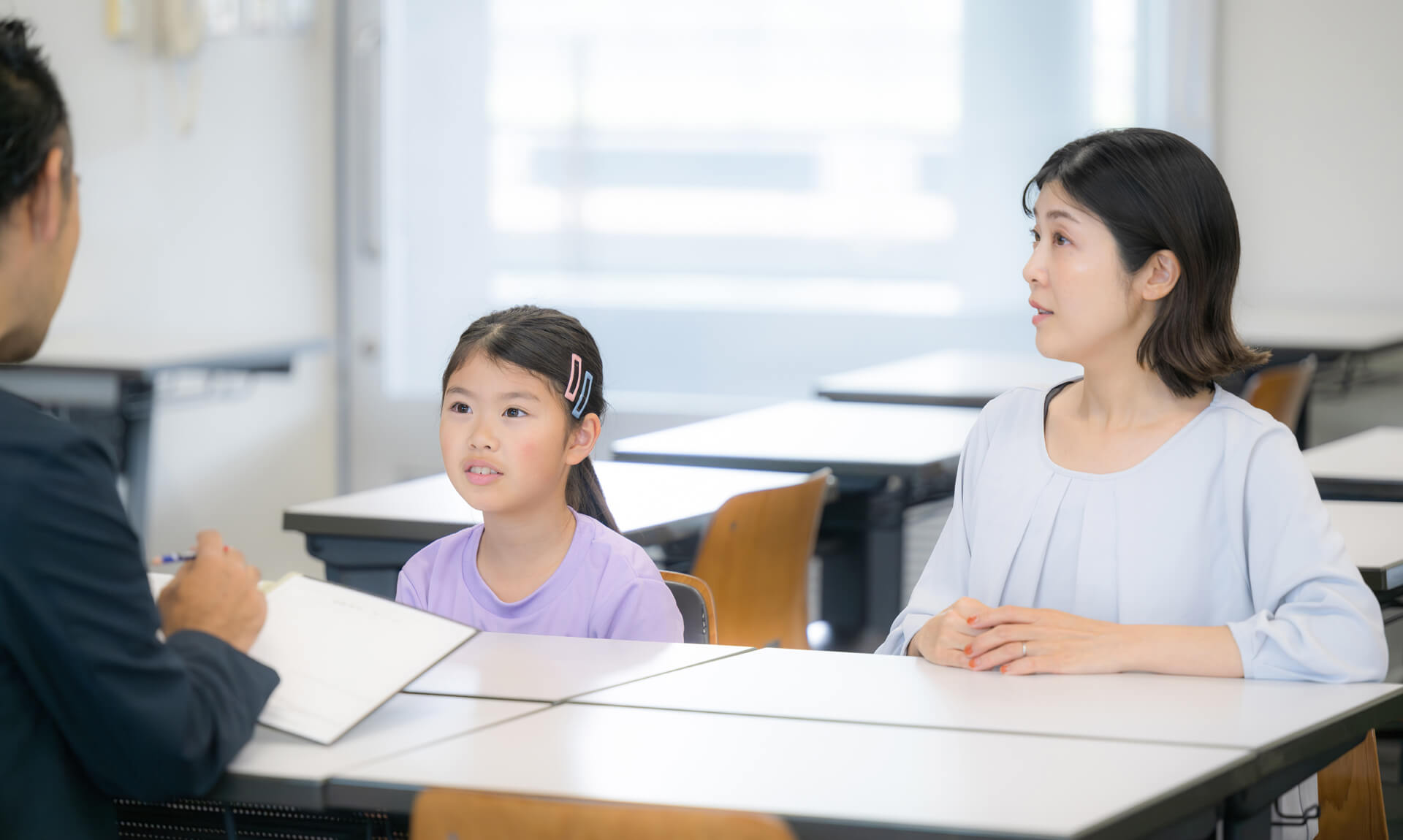 Mom and daughter meeting with teacher.