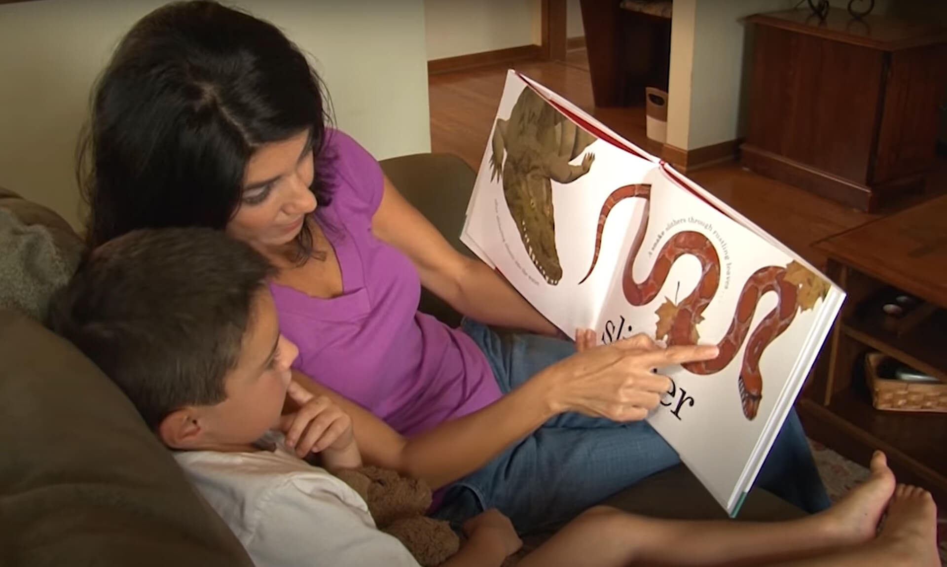 Mom points out a detail in a book she is reading to her young son.