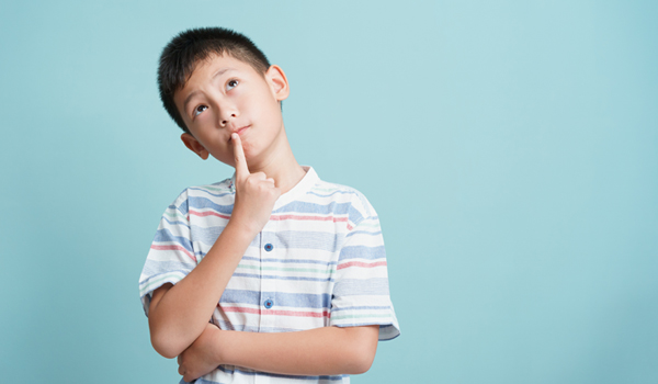 child pauses deep in thought on blue background