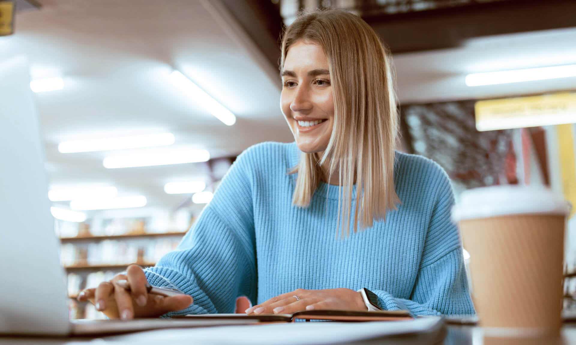 College PhD student studying with technology and e-learning on campus.