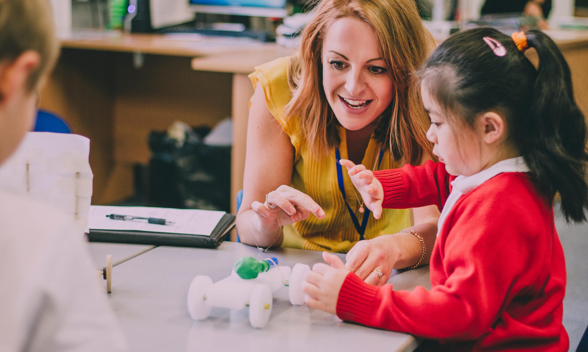 Teacher working with a child on a school project.