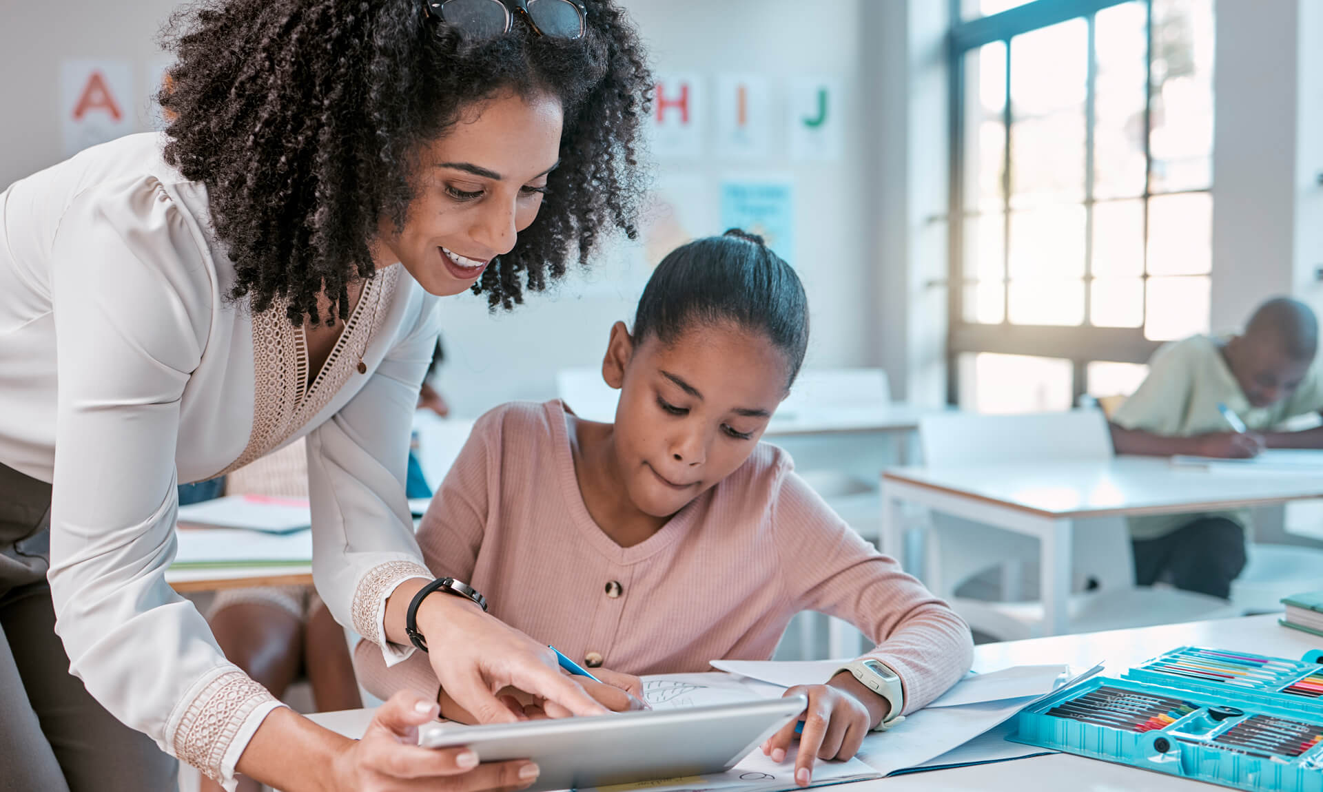 teacher helping young student, teaching creative work in book