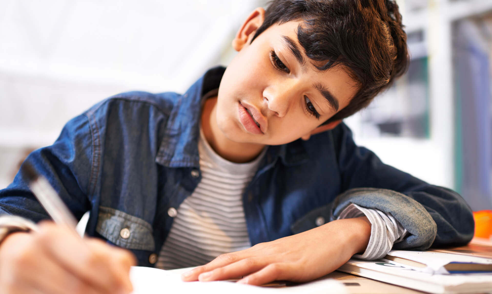young boy working on homework at desk